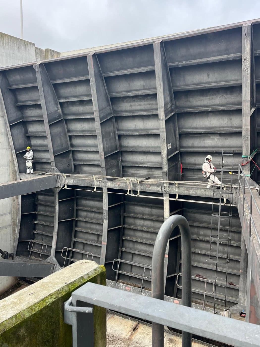 Equipa sobre a passadeira de acesso à estrutura metálica das comportas da barragem.