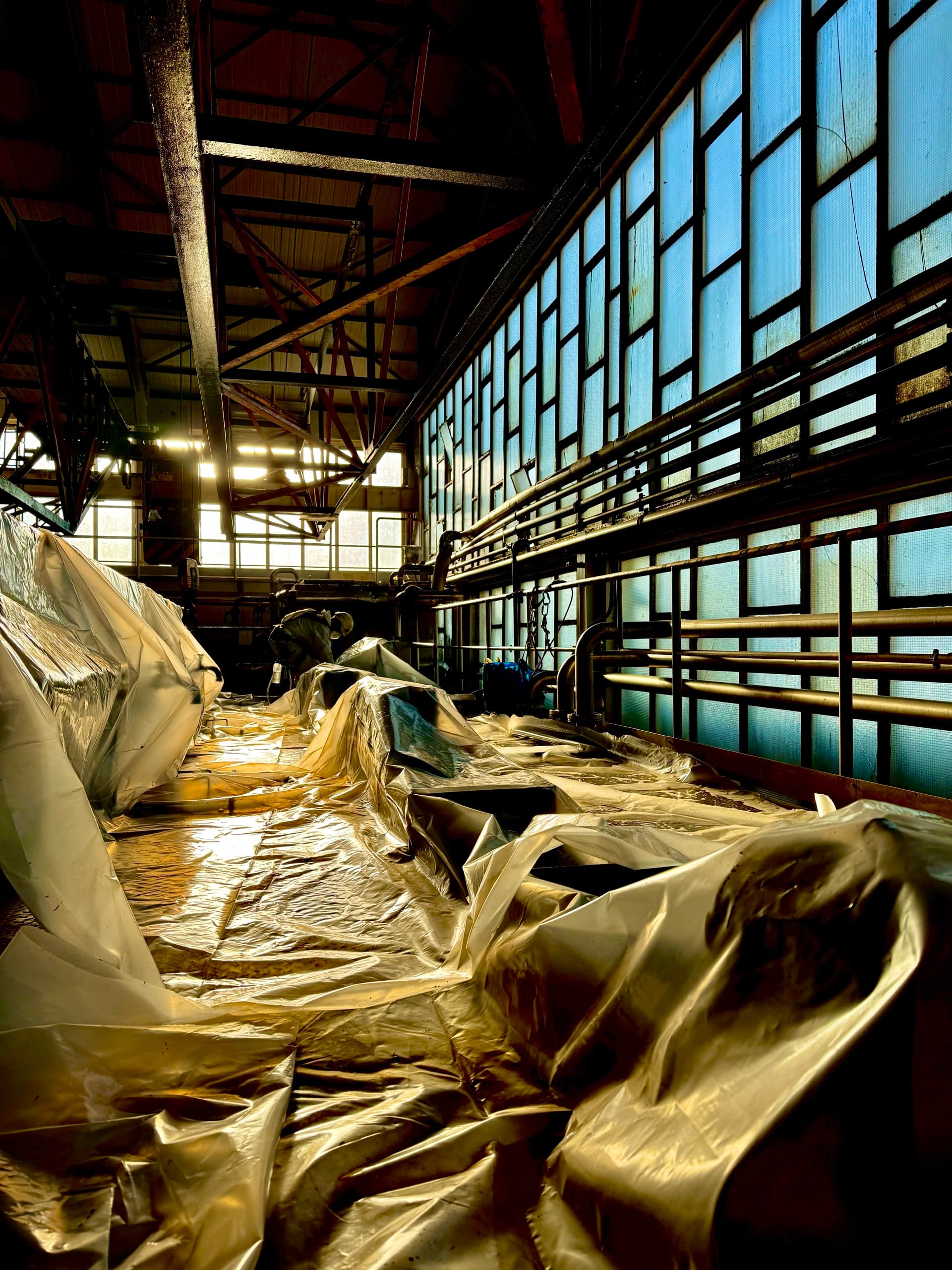 Interior da nave industrial com os equipamentos de produção integralmente protegidos antes dos trabalhos.