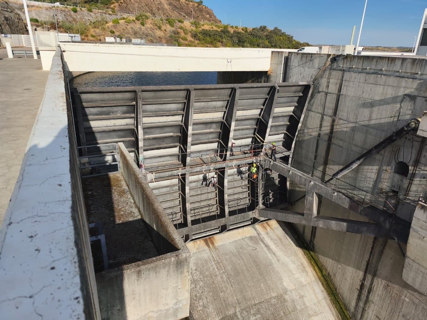 Descarregador de superfície de uma barragem no Alentejo, com as comportas metálicas e a equipa em trabalho.